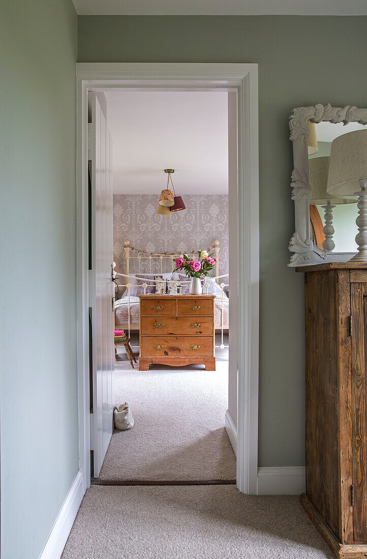 Chest of drawers in bedroom view through doorframe in detached 1950s Alford home Surrey UK