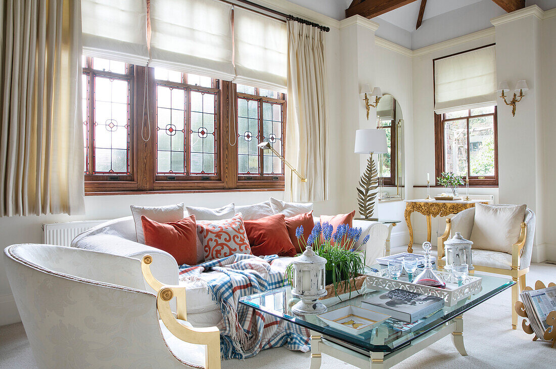 White sofa at window with glass topped table in West Sussex townhouse UK