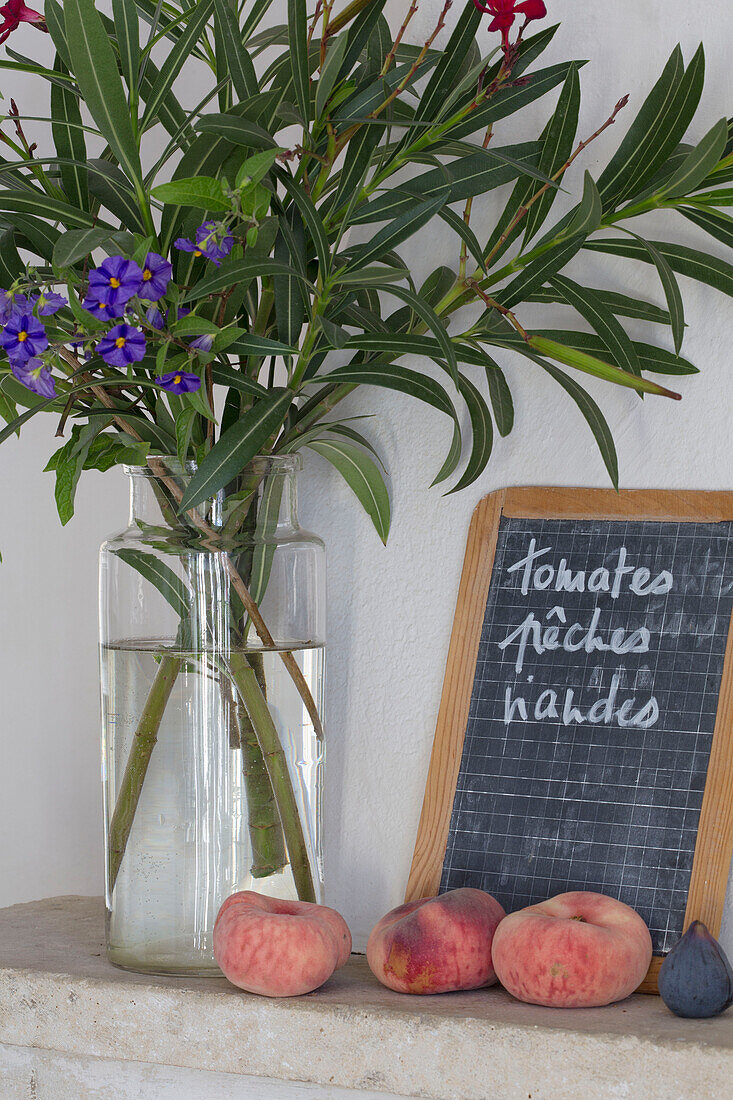 Schnittblumen und Pfirsiche mit Handschrift auf einer Tafel in einem provenzalischen Bauernhaus aus dem 19