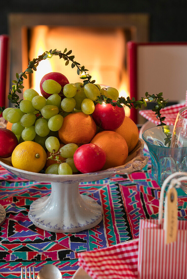 Fruit bowl on patterned fabric with lit fire in Hove apartment East Sussex UK