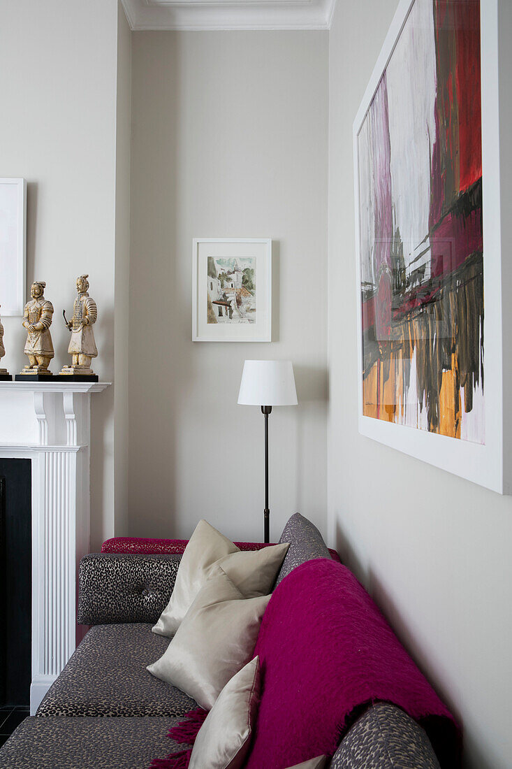 Large artwork by Rosa Navarro above sofa with pink blanket in Victorian terrace London UK