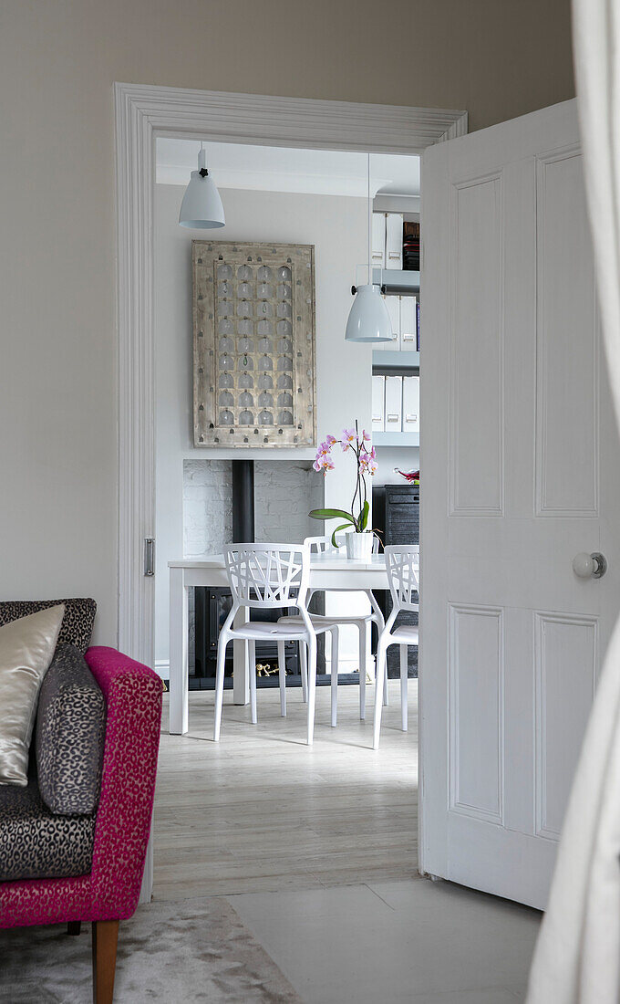 View through doorway to white dining table and chairs in modern Victorian terrace London UK