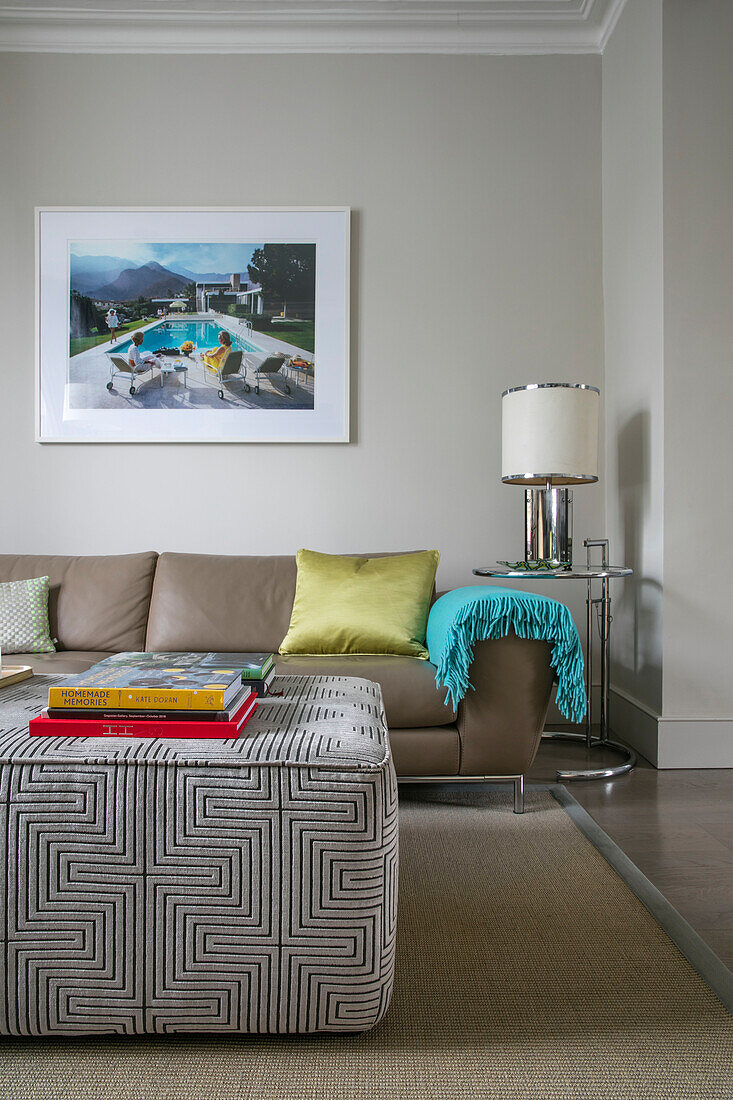 Framed artwork above sofa with geometric design on ottoman in London home UK