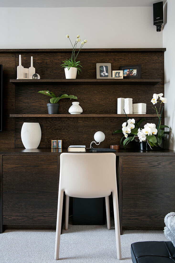 Desk and chair with ornaments on shelving in London home UK