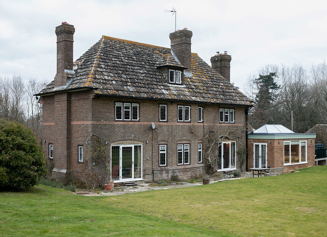 Freistehendes Backsteinhaus aus den 1930er Jahren mit Wintergartenanbau in West Sussex UK