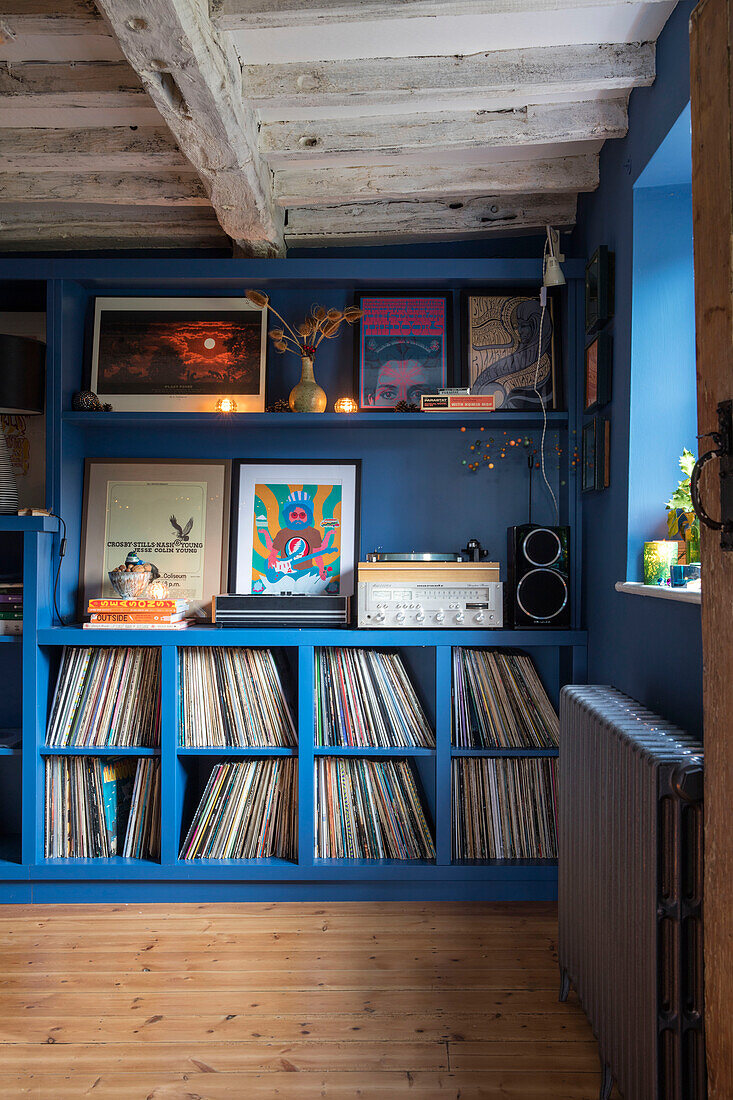 Vinyl collection and record player on blue shelving in Grade II listed Hampshire cottage built c1500