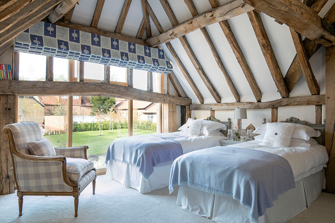 Twin room with upholstered larmchair in Hampshire barn conversion UK