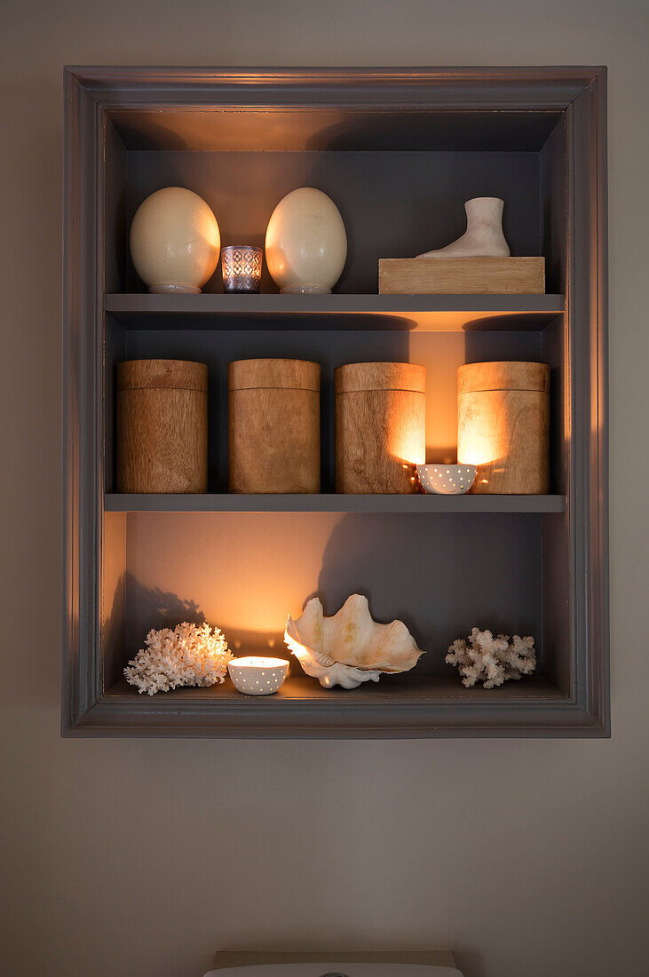 Ostrich eggs shells and coral on wooden shelf in bathroom of Norfolk cottage England UK