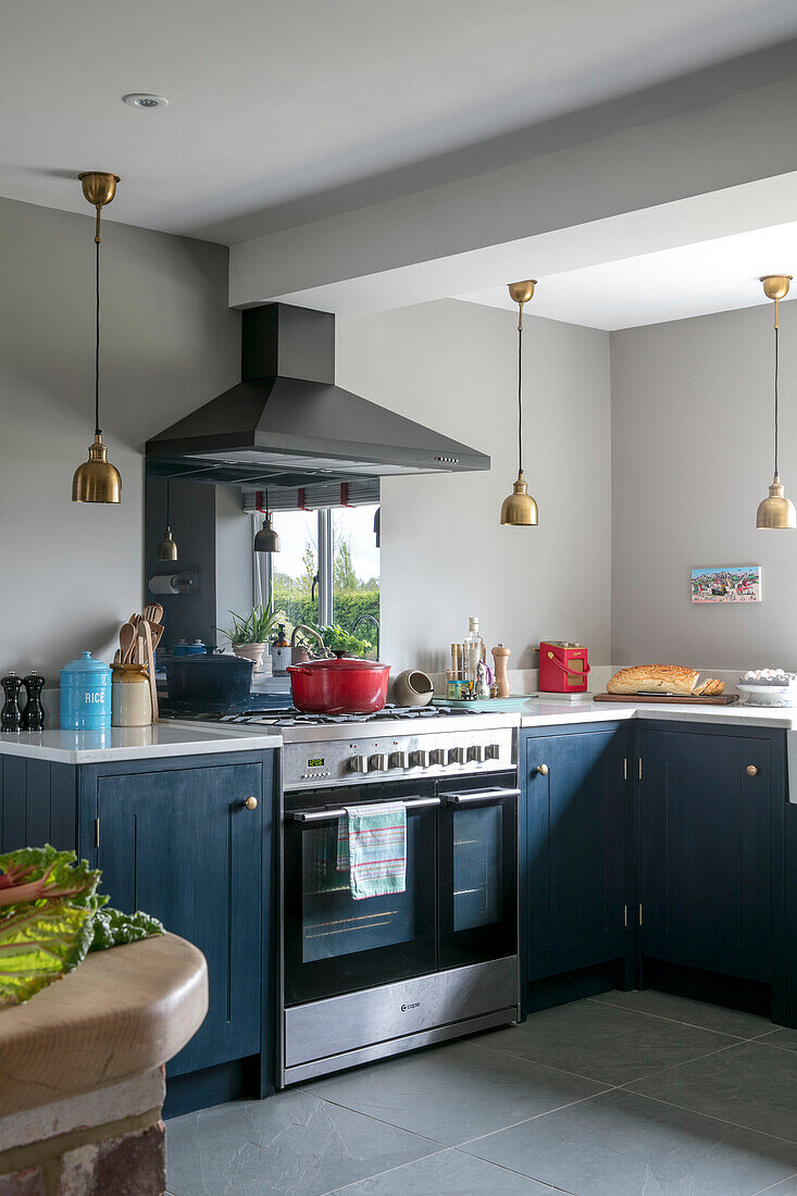 Goldfarbene Pendelleuchten in einer Küche mit tealfarbenen Schränken Hampshire England UK
