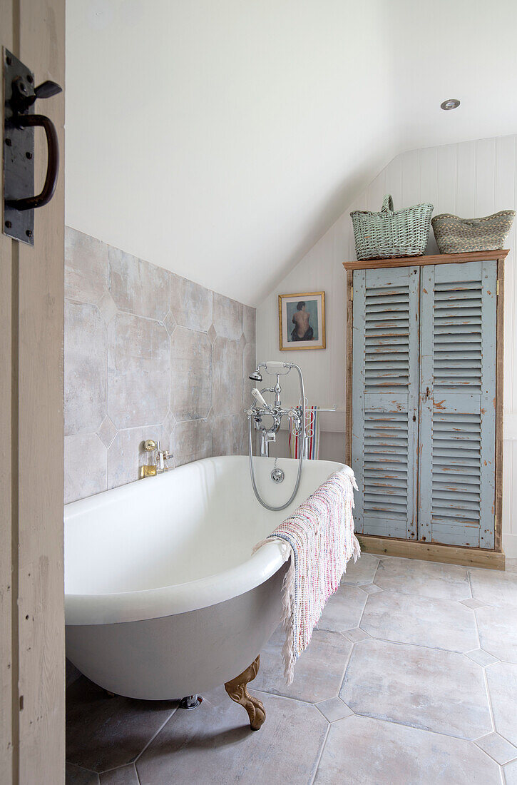 Schrank aus alten Fensterläden mit freistehender Badewanne in einem Bauernhaus in Surrey (UK)