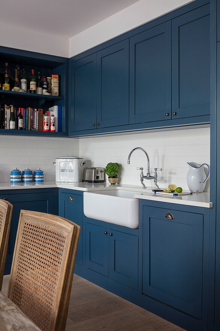 Belfast-Spülbecken mit Flaschen auf einem Regal und blauem Anstrich in der Küche einer Wohnung im Norden Londons UK