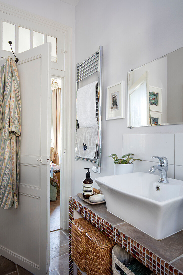 Mosaic tiled wash stand with towel rack and open door in bathroom of Issigeac townhouse Perigord France