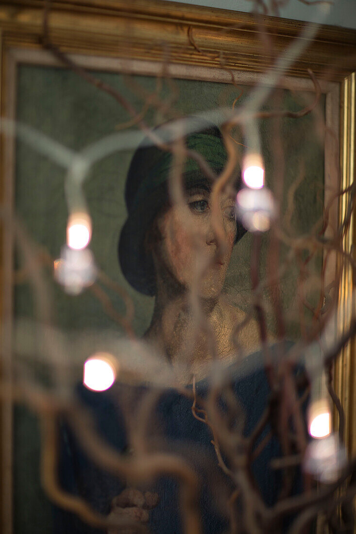 Gilt framed portrait of a woman and fairylights in Norfolk farmhouse UK