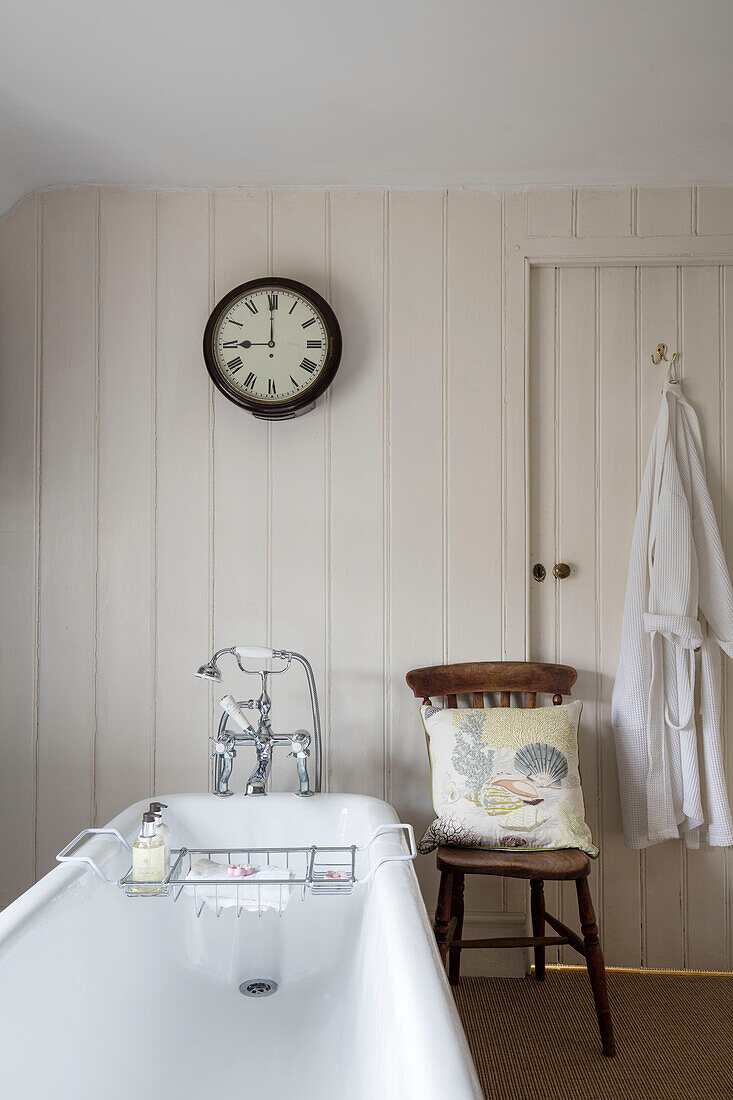 Alte Schuluhr über der Badewanne in einem unter Denkmalschutz stehenden georgianischen Bauernhaus, Somerset, UK