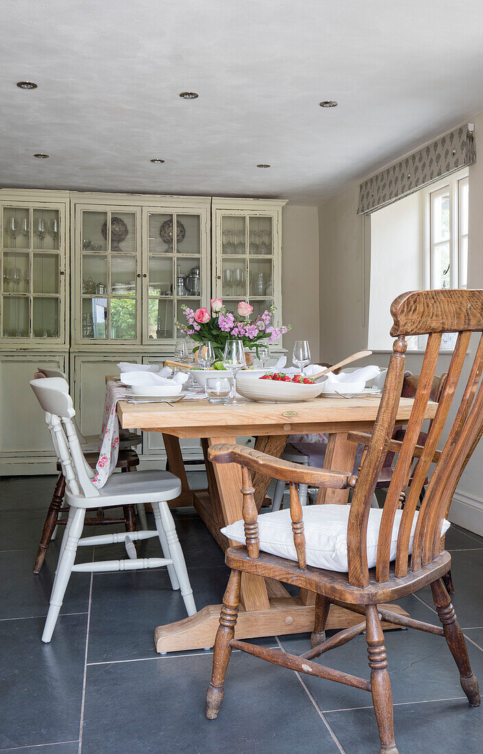 Ladderback chair at table with kitchen dresser in Grade II listed Georgian farmhouse Somerset, UK