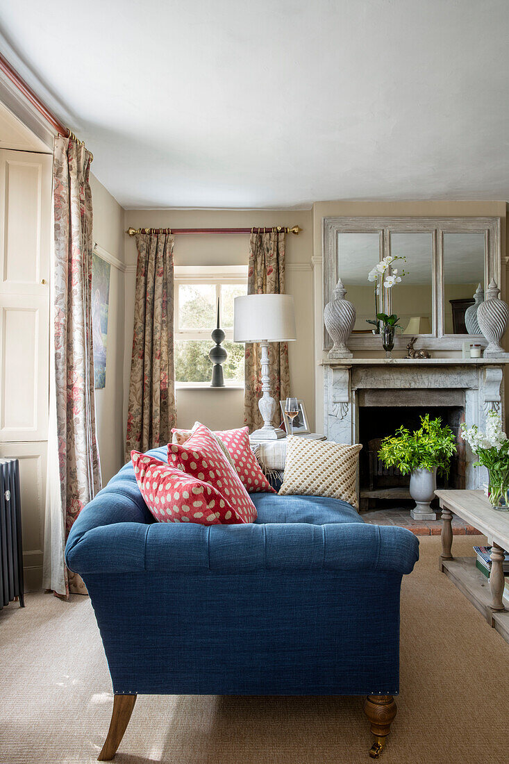 Sofa in blue linen with red polkadot cushions in Grade II listed Georgian farmhouse Somerset, UK