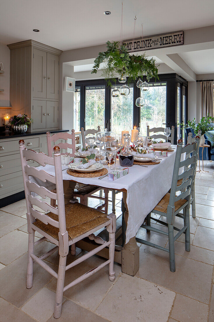 Upgecycelte Stühle um einen für das Weihnachtsessen gedeckten Tisch in einem Haus in Surrey UK