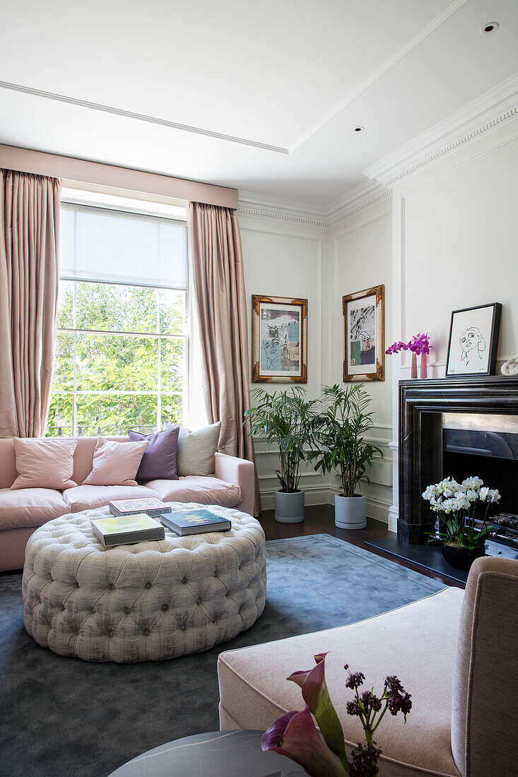 Pastel pink sofa with buttoned ottoman in London townhouse UK