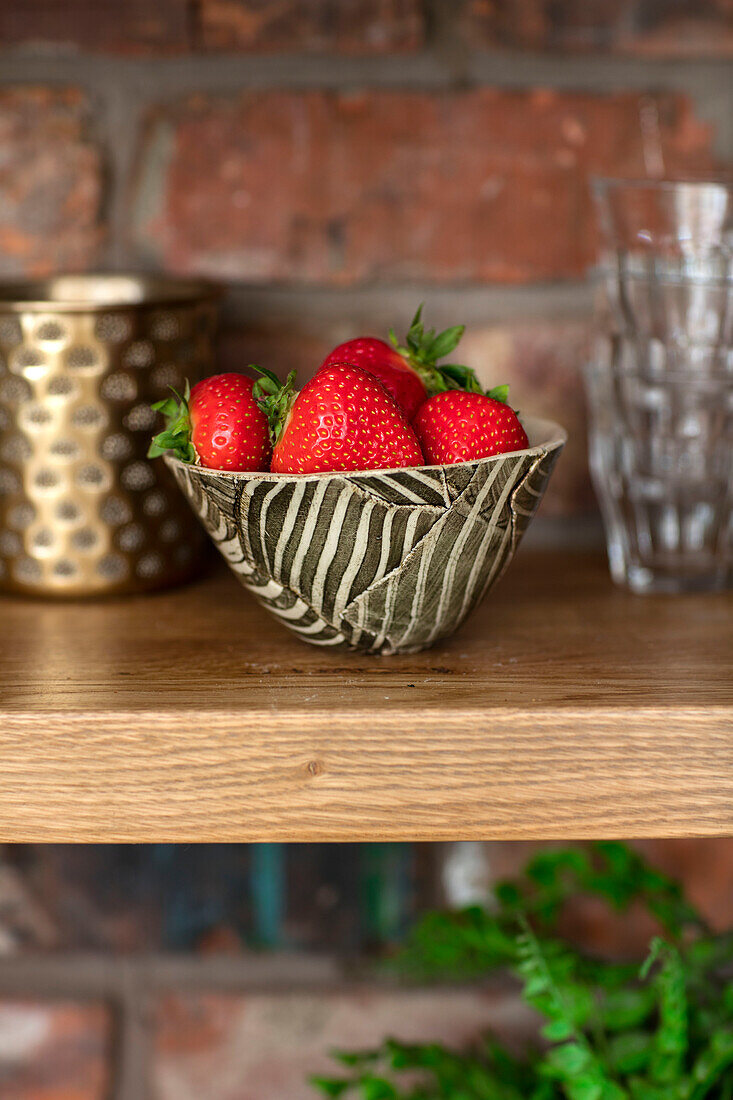 Strawberries in handmade bowl with exposed bricks in Manchester UK