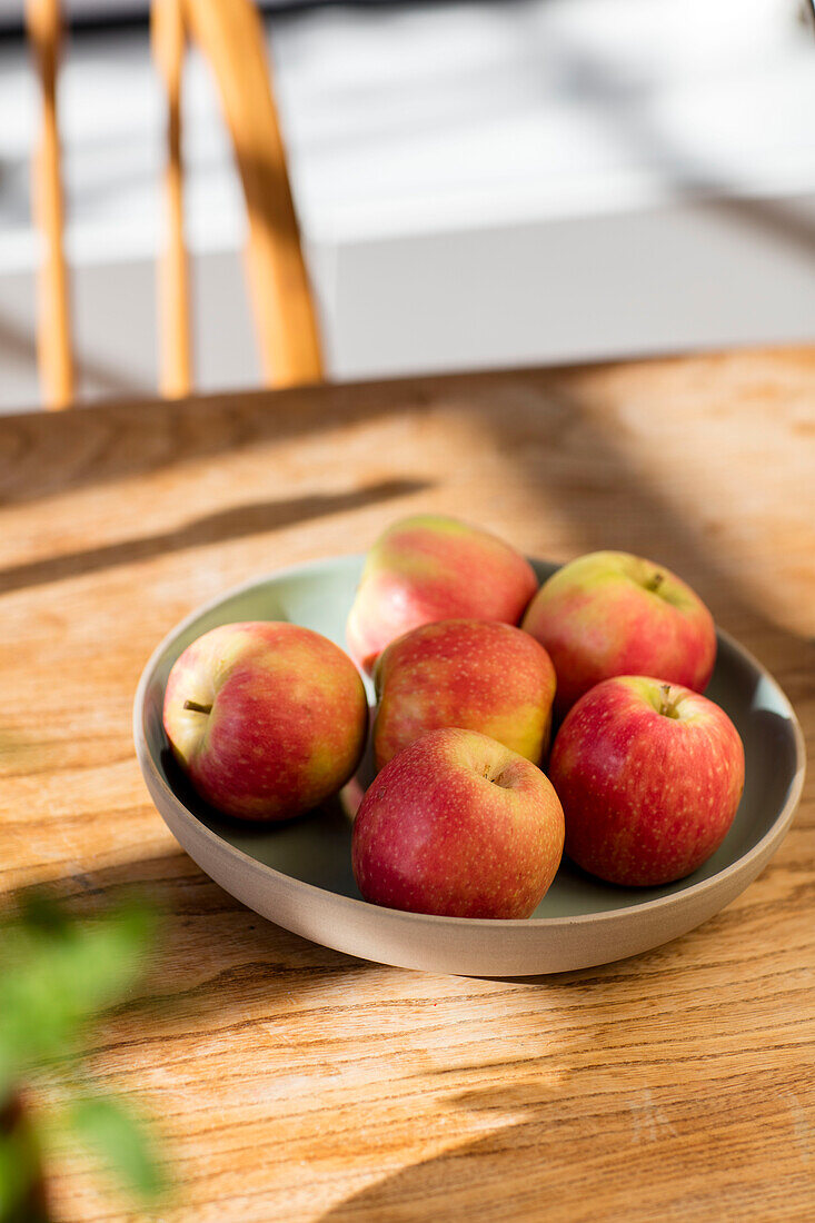 Bowl of apples in dappled sunlight family home Manchester UK