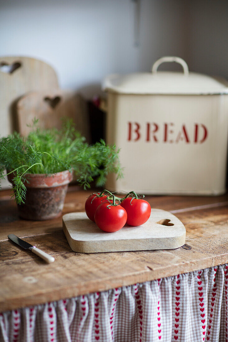 Tomatoes on chopping board with breadbin Barrow in Furness Cumbria UK