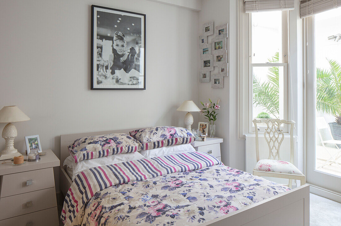 Print of Audrey Hepburn above bed with striped and floral reversible patterns in London home UK