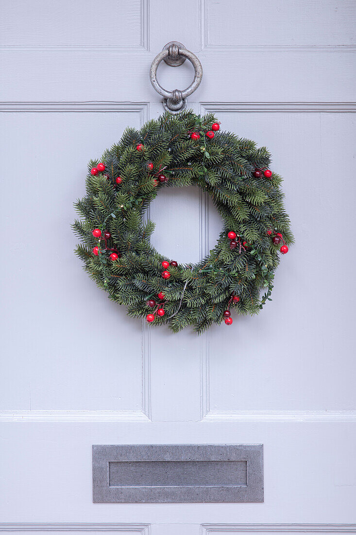 Weihnachtskranz mit silbernen Beschlägen an einer weißen Haustür Hampshire UK