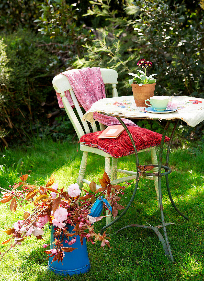 Painted chair at metal table in back garden Isle of Wight, UK