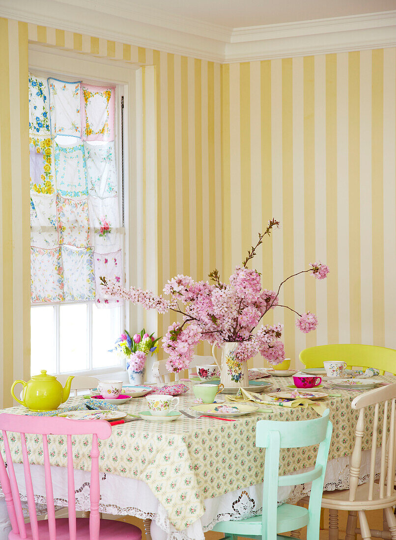 Pink blossom on table in room with yellow striped wallpaper