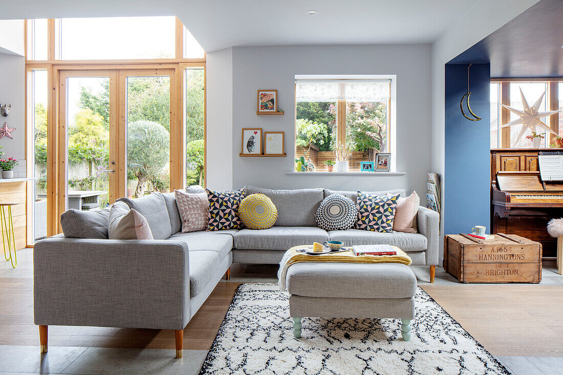 Light grey corner sofa and ottoman in open plan living room Sussex UK