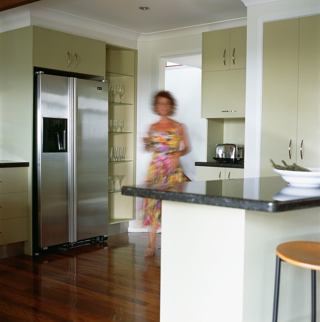 Woman walking into a contemporary kitchen