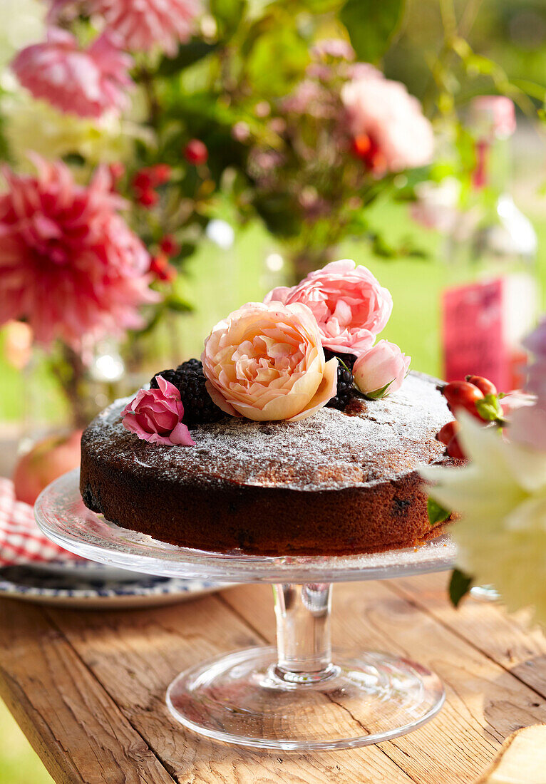 Late Summer picnic in garden with cakes fruit and flowers