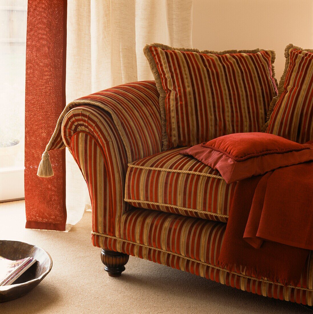 Red and gold coloured upholstered sofa with soft furnishings