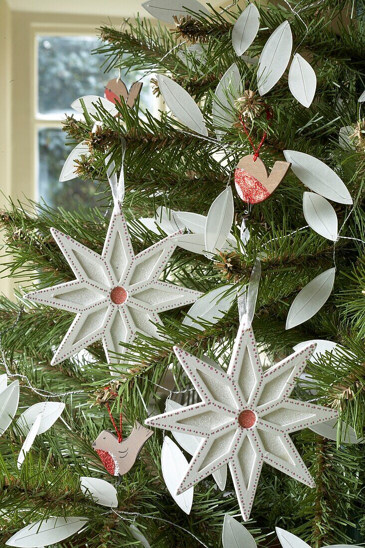 A Christmas tree decorated with white Christmas decorations