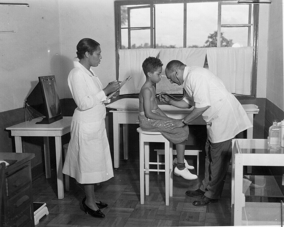 Doctor examining a boy for tuberculosis at a health centre