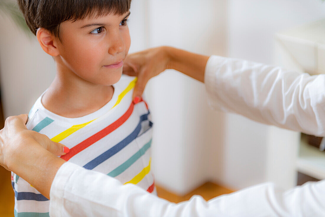 Pediatrician checking posture of a boy