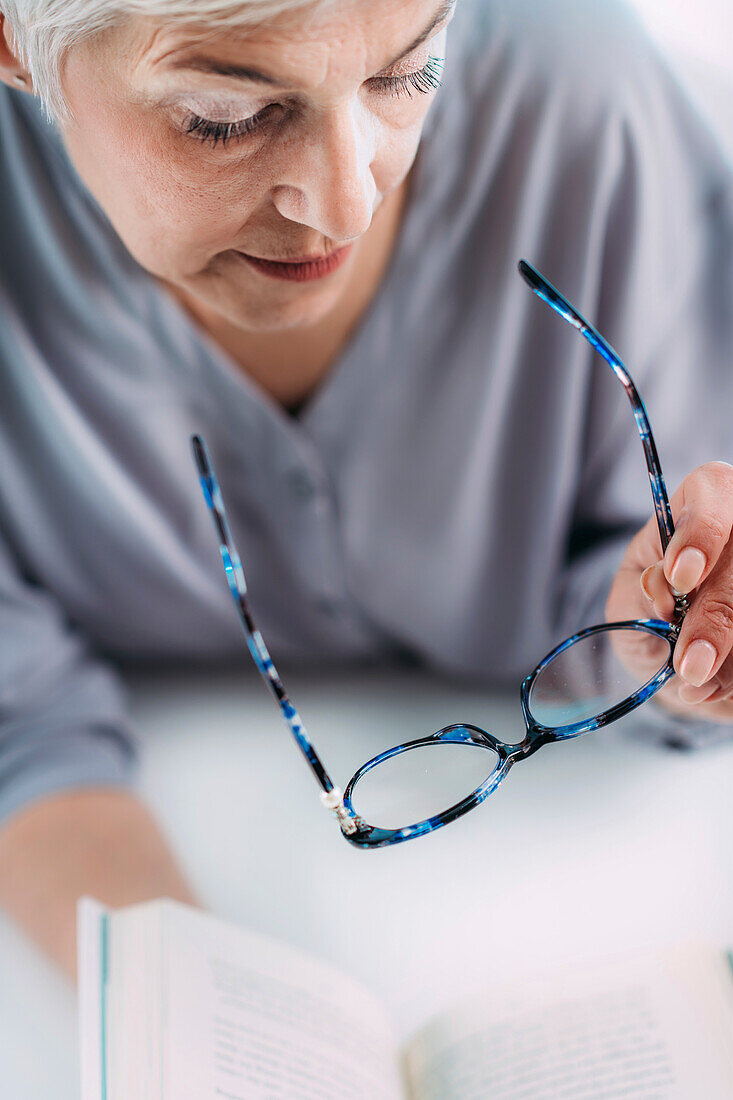Senior woman with eyeglasses struggling to read