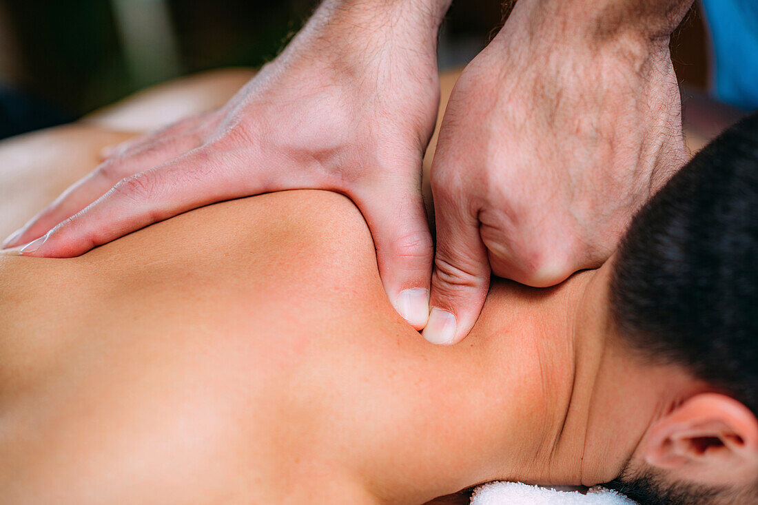 Physiotherapist massaging patient's shoulder