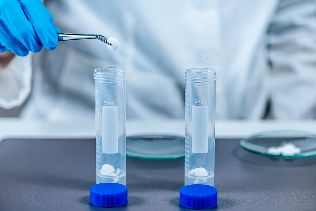 Scientist inserting pills into tubes