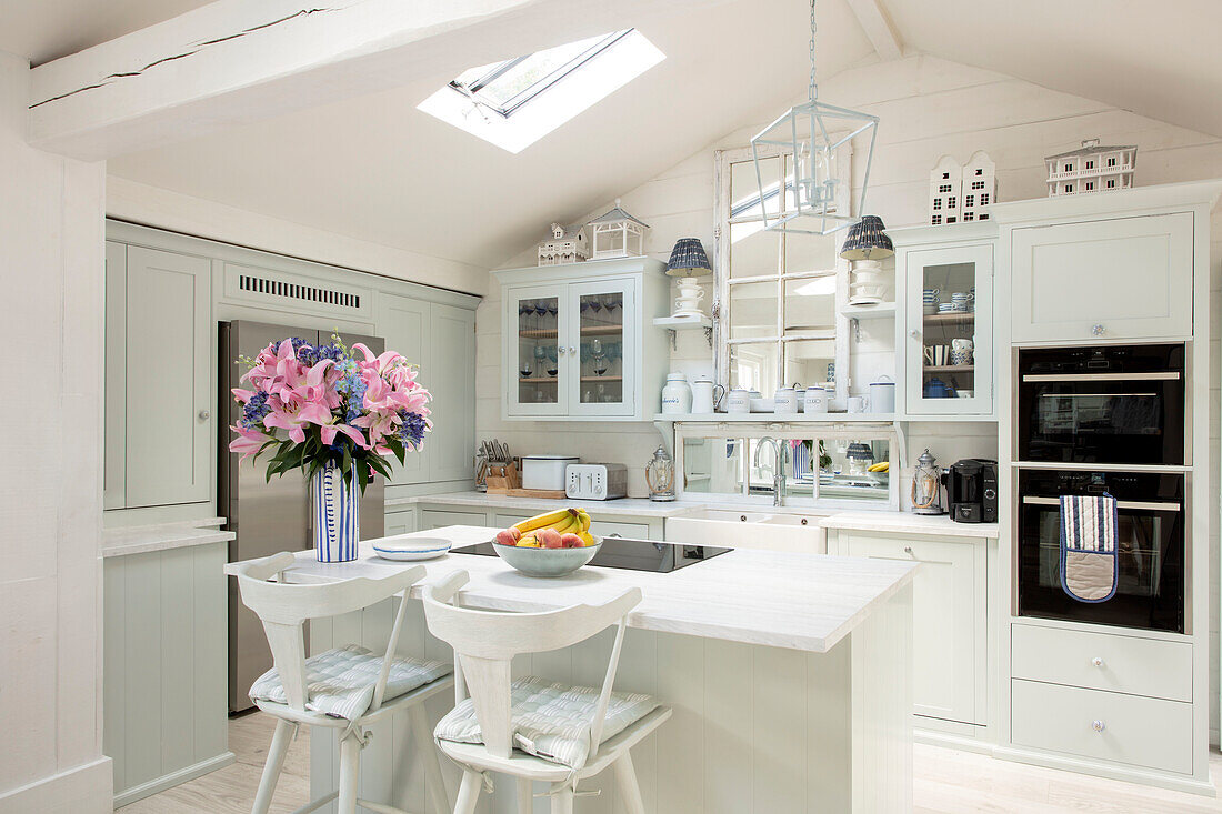 Bright country-style kitchen with cooking island and bouquet of flowers