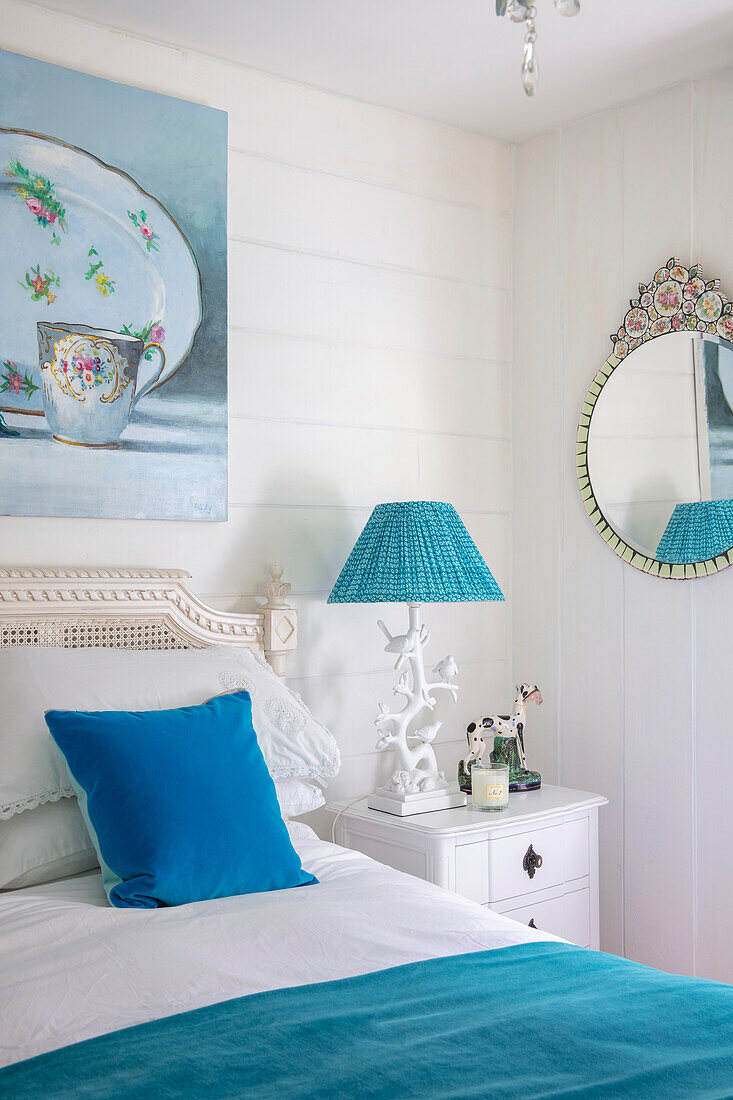 Bedroom in white and turquoise with vintage-style mirror