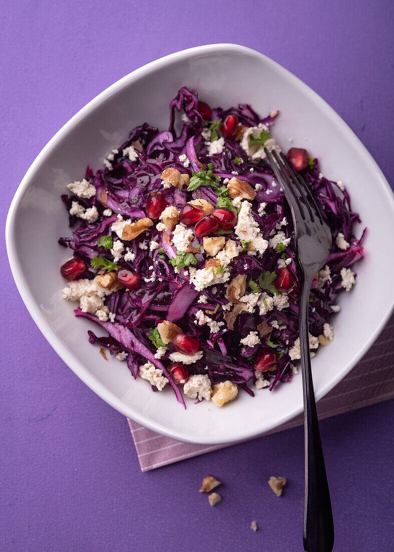 Vegan red cabbage salad with tofu, pomegranate seeds and walnuts