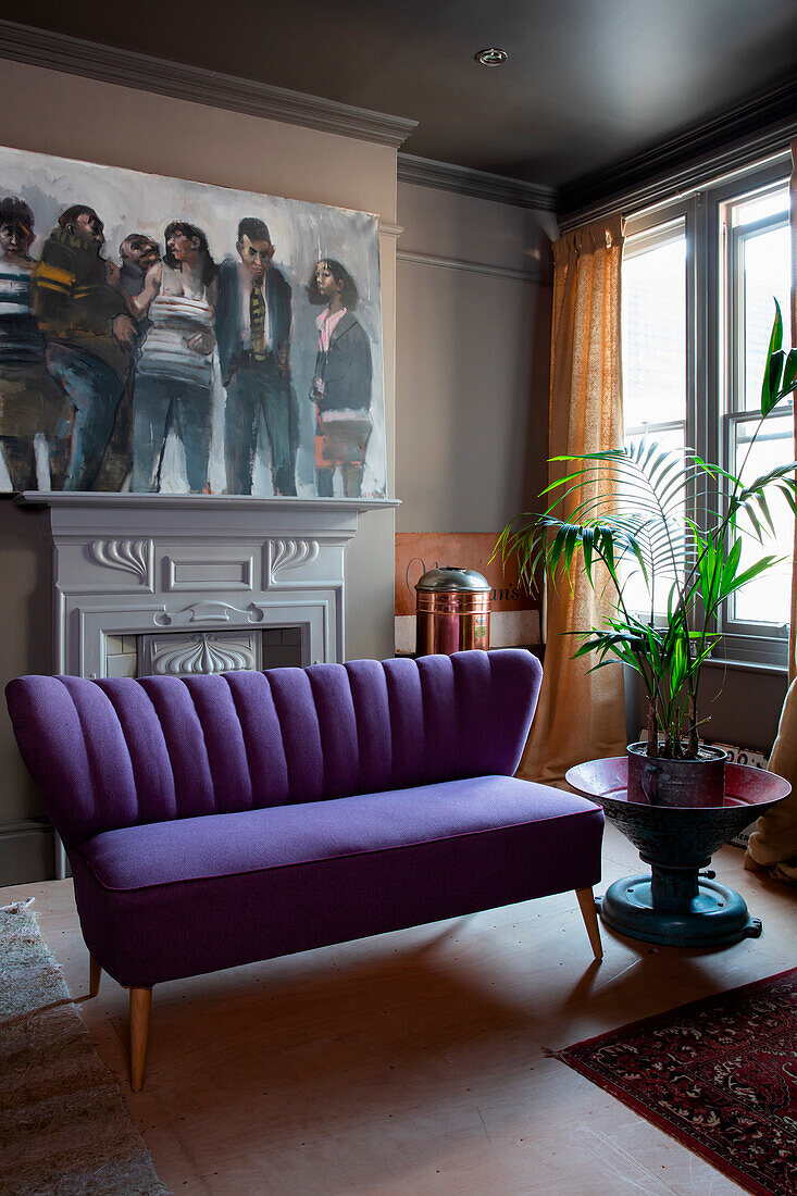 Purple sofa and large painting above the fireplace in the living room