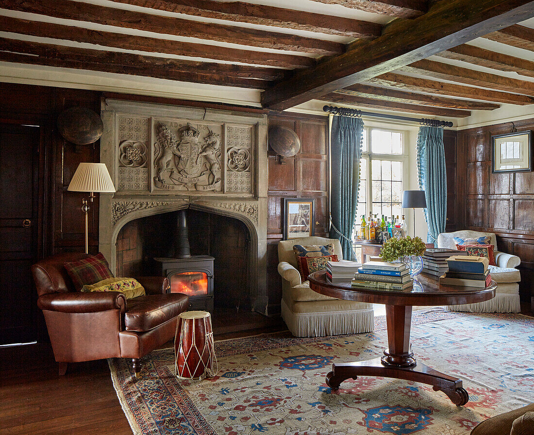 Lounge with leather armchairs in front of a fireplace