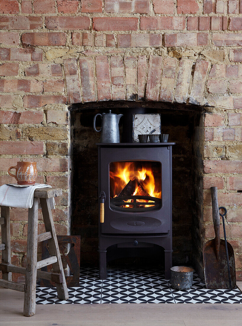 Wood-burning stove with fire, brick chimney and vintage decorations