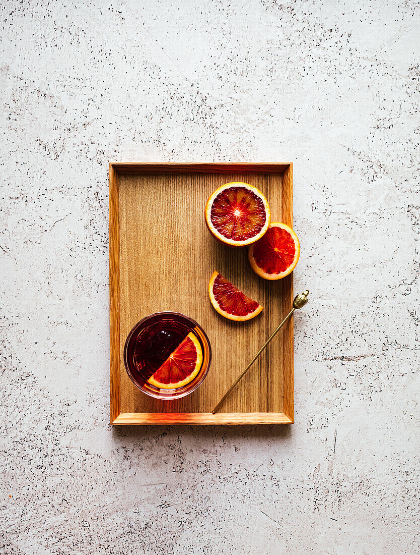 Negroni with a slice of Blood Orange on a wooden tray
