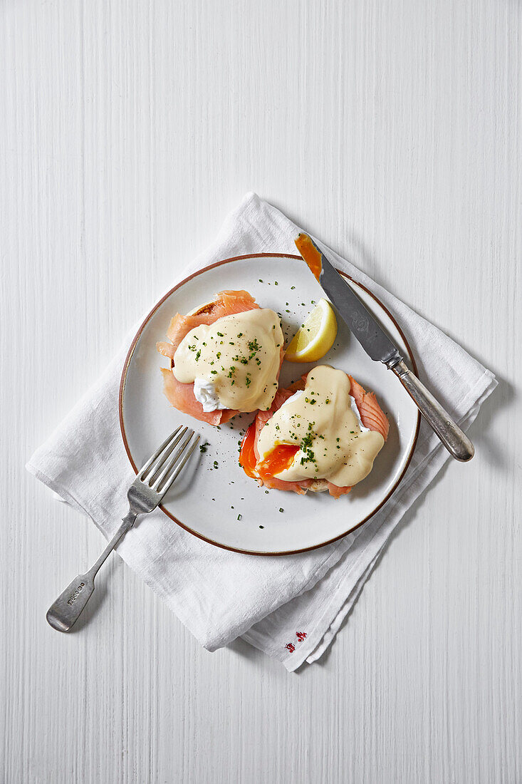 Poached eggs with runny yolks served with smoked salmon and a hollandaise sauce on muffins