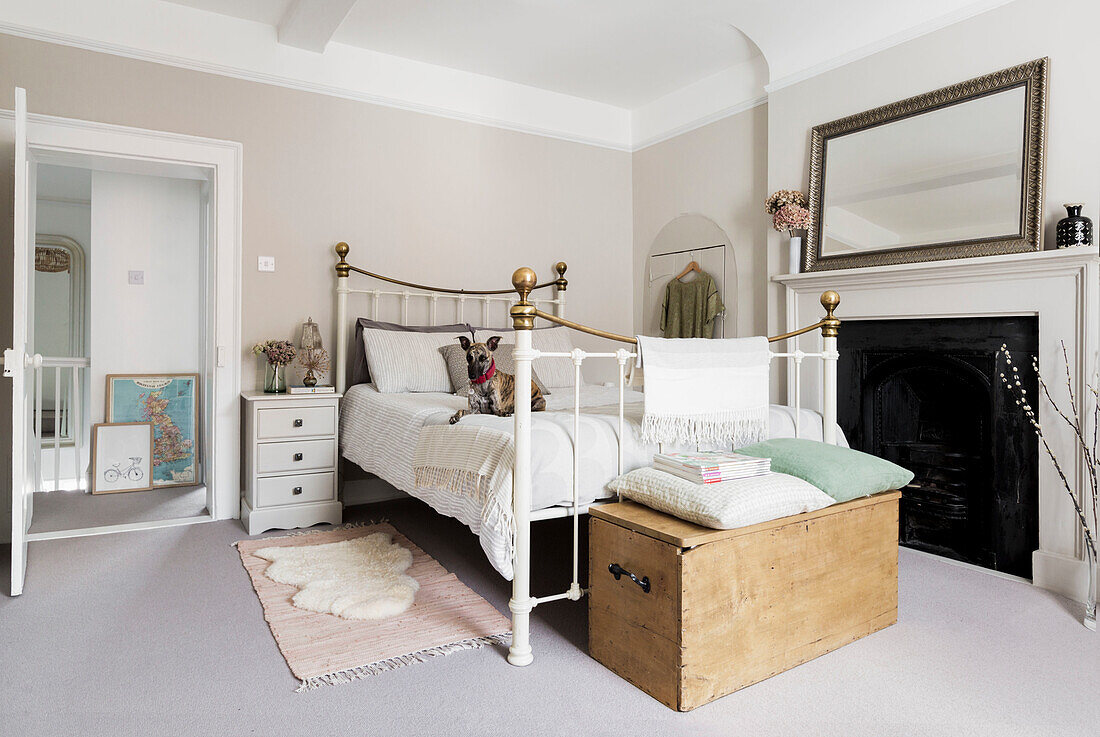 Metal bed with vintage look in the bedroom with fireplace and mirror