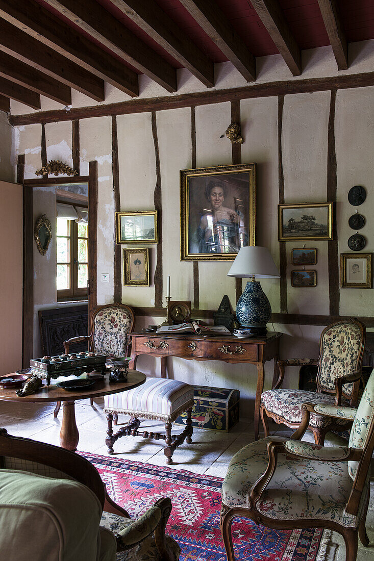 Upholstered furniture and antique desk in lounge with half-timbered wall