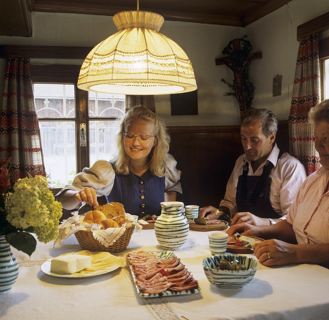 People eating hearty snack (Jause) in Austrian farmhouse